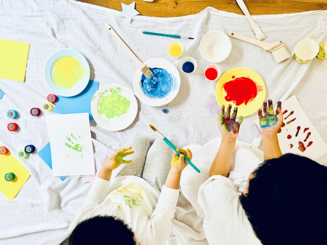 絵の具で手形遊びをする子ども